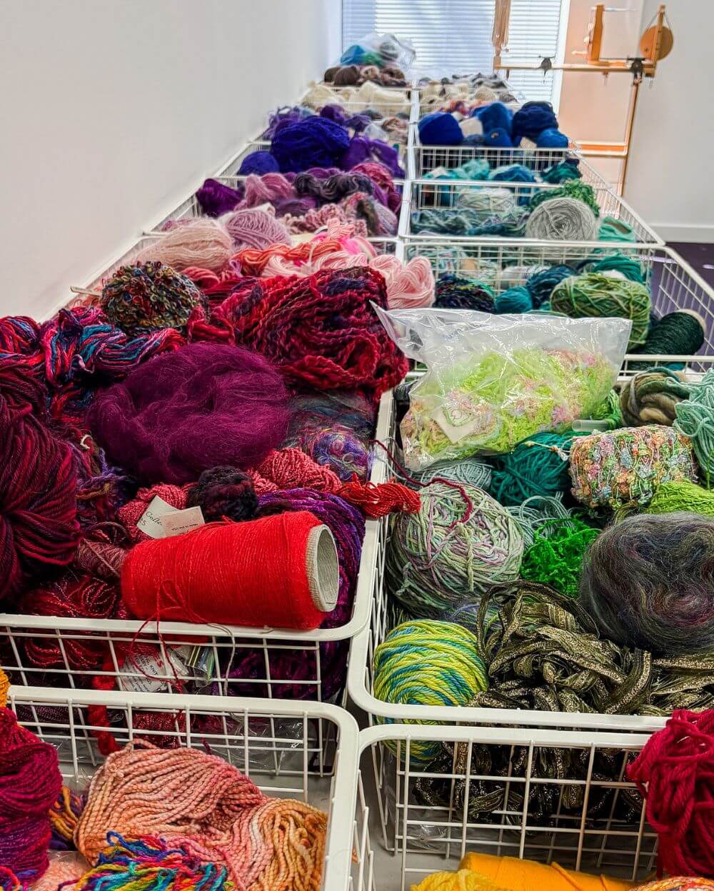 a closeup of a table covered in baskets of colorful yarn